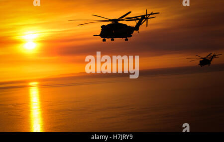 Due CH-53E Super Stallion elicotteri volare sopra l'oceano al tramonto mentre ritornando al Marine Corps Air Station Miramar Maggio 15, 2014 in Miramar, California. Foto Stock