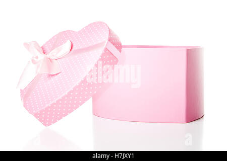 Un aperto, di colore rosa a forma di cuore, polka dot confezione regalo isolato su sfondo bianco Foto Stock