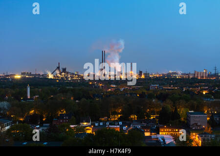 Vista di una grande coking e impianto siderurgico a Duisburg in Germania nella notte con coke quenching con produzione di vapore. Foto Stock