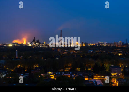 Vista di una grande coking e impianto siderurgico a Duisburg in Germania nella notte con maschiatura risultante in il bagliore rosso. Foto Stock