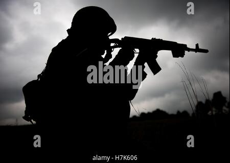 La silhouette di un soldato bulgaro con il suo fucile durante l'esercizio una rapida Trident a internazionale per il mantenimento della pace e il Centro di sicurezza Settembre 23, 2014 in Yavoriv, Ucraina. Foto Stock