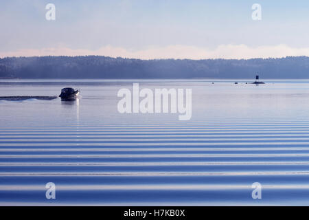 Il motoscafo sul calmo mare freddo con belle piccole onde in primo piano. Foto Stock