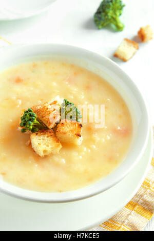 Verdure e formaggio cheddar minestra in crema di broccoli e crostini in bianco ciotola close up - in casa heathy cibo vegetariano Foto Stock