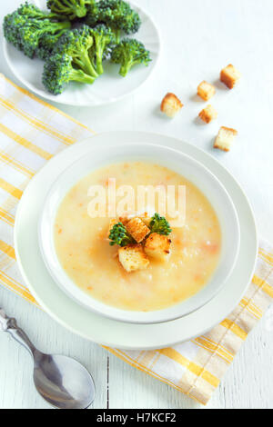 Verdure e formaggio cheddar minestra in crema di broccoli e crostini in bianco ciotola close up - in casa heathy cibo vegetariano Foto Stock