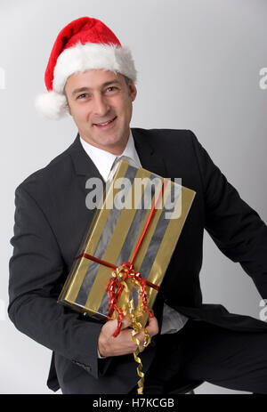 Uomo d affari e con il regalo di Natale e Santa hat Foto Stock