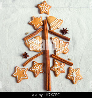 Albero di Natale fatto da Natale gingerbread cookies sul lino sfondo con anice stelle e bastoncini di cannella, festiv fatti in casa Foto Stock