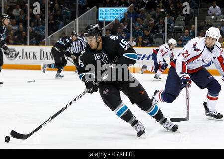 Febbraio 17, 2011; San Jose, CA, Stati Uniti d'America; San Jose Sharks ala destra Devin Setoguchi (16) dei pattini con il puck Passato capitelli di Washington Centro Brooks latch (21) durante il primo periodo di HP Pavilion. Foto Stock