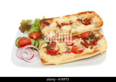 Aprire la mozzarella, il formaggio Cheddar, pomodoro, pancetta e basilico pannini con contorno di insalata su una piastra isolata contro bianco Foto Stock