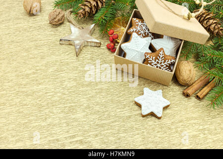 Natale gingerbread cookies in confezione regalo, dadi e spezie su oro di incarto lo sfondo della carta Foto Stock