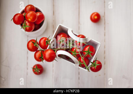 Mazzetto di ciliegia matura pomodori collocato in un tavolo di legno Foto Stock