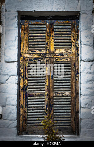 In legno massiccio con finestra clappe chiuse isolate su muro bianco Foto Stock