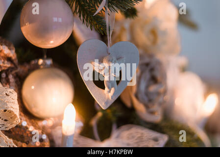 Christmas Angel e le sfere su un ramo di albero con luci decorato come candele Foto Stock