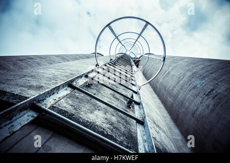 Esterno del vecchio edificio industriale con scaletta. Architettura di calcestruzzo. Fabbrica abbandonata. Foto Stock