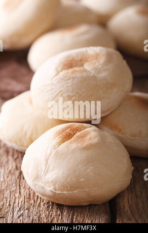 Pane appena sfornato pane arabo batbout macro sul tavolo. In verticale Foto Stock