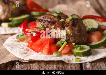 Bagno turco kofta con verdure fresche su un pane piatto vicino sul tavolo orizzontale. Foto Stock