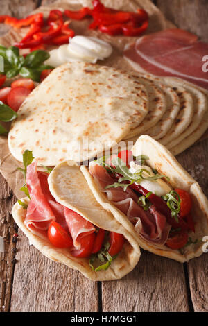 Cucina Italiana la piadina farcita con prosciutto e formaggio e verdure vicino sul piano verticale. Foto Stock