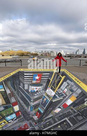 Una donna saldi sul bordo di una visualizzazione 3D di Times Square, New York, creato dall'artista di strada Joe Hill al punto di osservazione su Londra il South Bank. Foto Stock