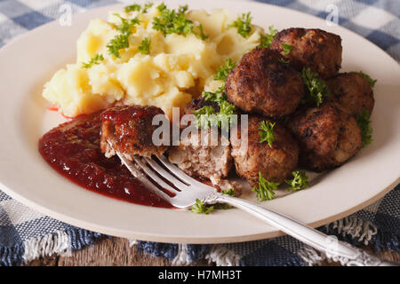 Polpette svedese kottbullar, lingonberry salsa con un contorno di purè di patate sulla piastra closeup. orizzontale Foto Stock