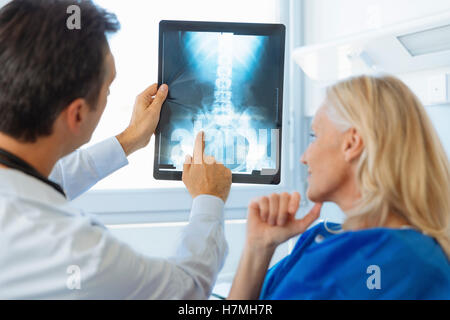 Medico mostrando Xray per un senior paziente in ospedale Foto Stock