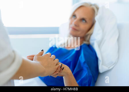 Medico tenendo mano del paziente nella stanza di ospedale Foto Stock