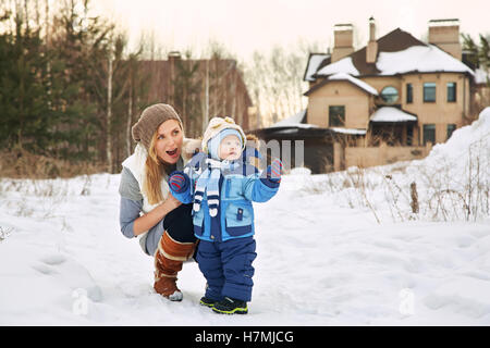 Felice la madre e il bambino in winter park Foto Stock