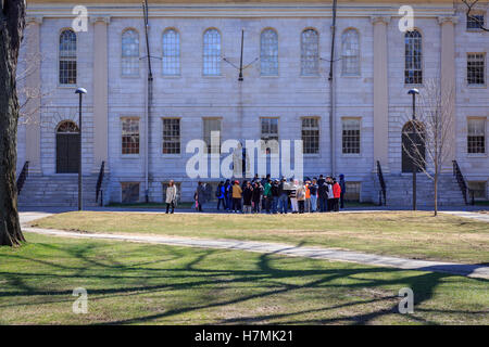 Gruppo turistico riuniti intorno al John Harvard statua in Harvard Yard, Cambridge, MA, Stati Uniti d'America. Foto Stock