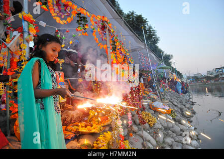 Kathmandu, Nepal. 6 Nov, 2016. Una ragazza ha celebrato dal fuoco ardente cracker come devoti eseguita rituali tradizionali a Kamal Pokhari Chhath Puja Festival, il culto del dio Sole, è comune in Nepal Terai della regione ed è celebrata in Kathmandu nonché dal Terai europee e in India. Il culto deve essere basata su uno stagno, un fiume o una qualsiasi fonte d'acqua, come per la tradizione religiosa. Credito: Narayan Maharjan/Pacific Press/Alamy Live News Foto Stock