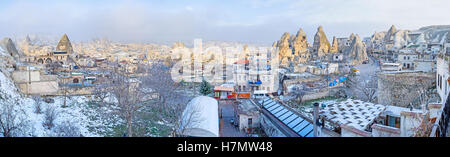 Panorama di inverno città di Goreme con le numerose rocce appuntite tra le case e gli alberghi turistici, Cappadocia, Turchia. Foto Stock