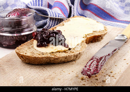 Slice di soda irlandese con pane e marmellata di ribes nero su una lastra di legno Foto Stock