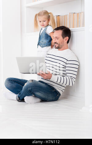 Allegro padre piacevole che mostra un video a sua figlia Foto Stock