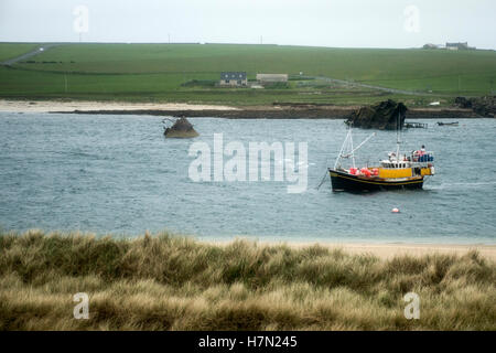 Isola delle Orcadi Scozia scapa bay barca davanti sunken arrugginito relitto della nave Foto Stock