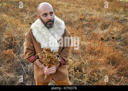 Concetto di vintage con un uomo con un mazzo di fiori secchi Foto Stock