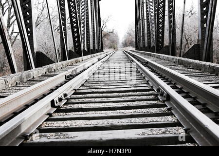 Close up di acciaio e legno treno tracce sull uomo made in treno o locomotore ponte sul fiume Foto Stock