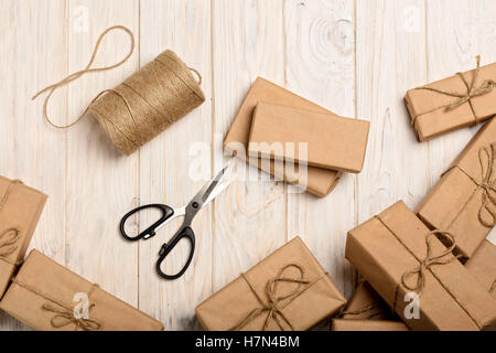 Avvolgimento di regali di Natale in carta kraft e corda. Foto Stock