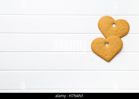 Gingerbread forma cuore sul tavolo bianco. Vista dall'alto. Foto Stock