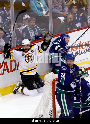 Giugno 15, 2011; Vancouver, BC, Canada; Boston Bruins center Patrice Bergeron (sinistra) celebra dopo con un punteggio a breve consegnata obiettivo passato Vancouver Canucks defenceman Christian Ehrhoff (5), defenceman Alexander Edler (23) e portiere Roberto Luongo nel secondo periodo di gioco sette del 2011 Stanley Cup Finals di Rogers Arena. Foto Stock
