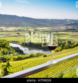 Bicchiere di vino isolato che si affaccia in Piemonte, Italia vigneti Foto Stock