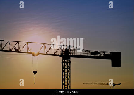 Gru a torre in un cantiere di sunrise Foto Stock