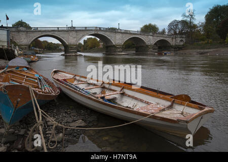 Richmond Upon Thames, barche giacenti lungo il letto del fiume in superficie durante la bassa marea sul grigio di un pomeriggio autunnale, Greater London, Regno Unito Foto Stock