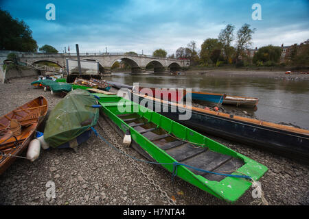 Richmond Upon Thames, barche giacenti lungo il letto del fiume in superficie durante la bassa marea sul grigio di un pomeriggio autunnale, London Borough of Richmond, Esterno Londra, Regno Unito Foto Stock