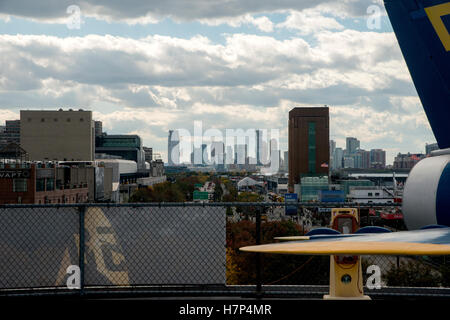 La città di New York dietro i turisti e museo aereo della USS Intrepid portaerei Foto Stock