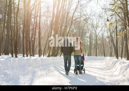 Famiglia giovane camminare con il passeggino in posizione di parcheggio Foto Stock