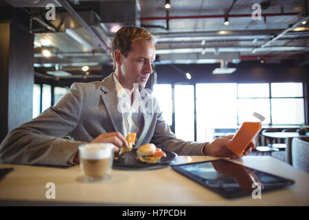 Imprenditore avente la prima colazione nella caffetteria Foto Stock