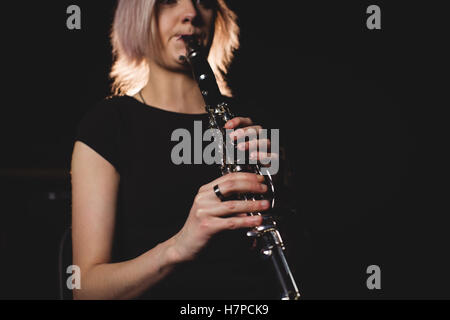 Donna che gioca un clarinetto nella scuola di musica Foto Stock