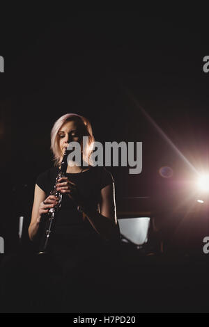 Donna che gioca un clarinetto nella scuola di musica Foto Stock