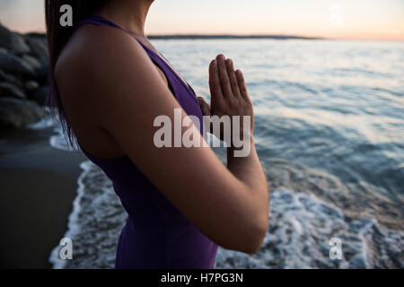 La sezione centrale della donna meditando sulla spiaggia Foto Stock