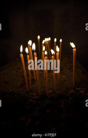 Candele accese su sfondo nero Foto Stock