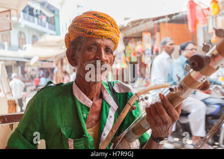 Un indiano di Rajasthani uomo giocando un Ravanahatha un tradizionale strumento musicale, Pushkar, India Foto Stock