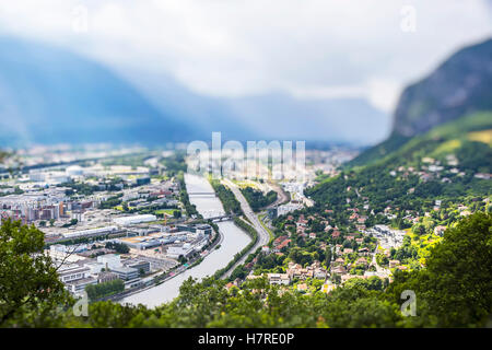 La città di Grenoble e fiume Isere, Francia. Pittoresca veduta aerea da Bastille in estate giorno nuvoloso. Tilt-shift Effetto Miniatura Foto Stock