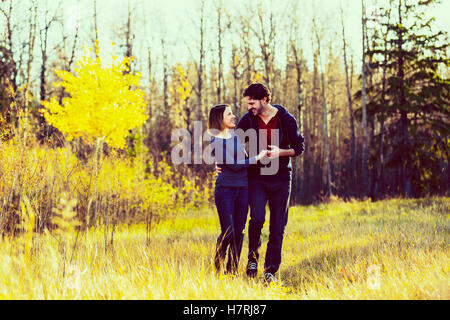 Una giovane coppia camminare e fingendo di danza in un parco della città in autunno; Edmonton, Alberta, Canada Foto Stock